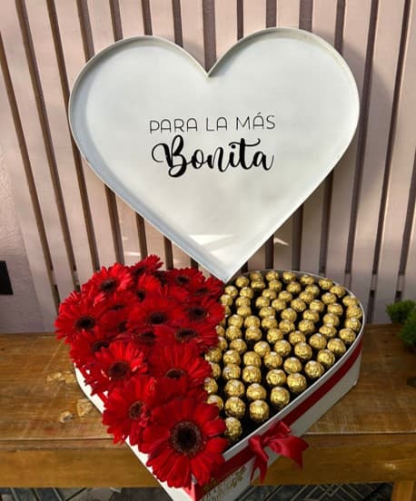 Corazón gigante con tapa y mensaje, con gerberas rojas y ferreros